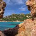 vue entre deux rochers d'une plage en corse